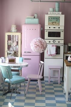 an old fashioned kitchen with pink and blue accents