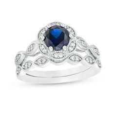 Ask for her hand and her heart with this gorgeous bridal set. Crafted in cool 10K white gold, this beautiful style showcases a 6.0mm lab-created bright blue sapphire wrapped in a floral frame adorned with sparkling diamonds and intricate milgrain detailing. The shank lends heirloom appeal with sculpted marquise shapes shimmering with petite diamonds and milgrain detailing. On your wedding, complete her look with the coordinating wedding band that features glistening diamonds in milgrain-lined ma White Sapphire Wedding Set, Zales Engagement Rings, Blue Sapphire Wedding Ring, Rings Sapphire, Sapphire Wedding Rings, Silver Lab, Diamond Frame, Sapphire And Diamond Ring, Sapphire Engagement Ring Blue