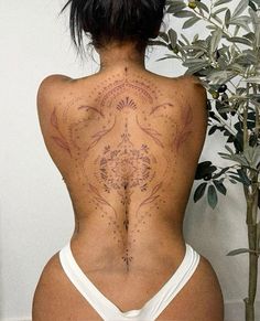 the back of a woman with tattoos on her body