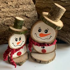 two snowmen made out of wood sitting next to each other