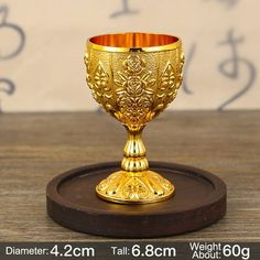 a golden cup sitting on top of a wooden table