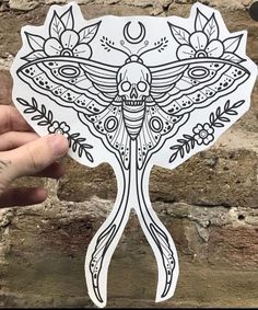 a hand holding up a sticker with an intricate design on it