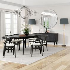 a dining room with white walls and wooden flooring, black table surrounded by chairs