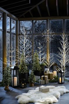 a room filled with lots of windows covered in frosty trees and lit up candles