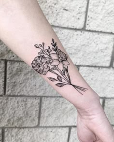 a black and white flower tattoo on the left arm, with flowers in it's center