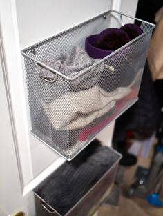 an organized closet is shown with clothes and socks in the bins on the door