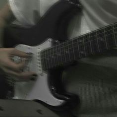 a man is playing an electric guitar in black and white photo with blurry background