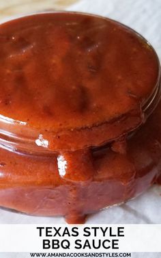 two jars filled with bbq sauce sitting on top of a tablecloth covered napkin