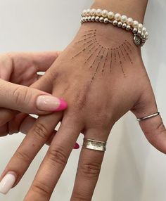 a woman's hand with two different designs on her fingers and one is holding the other