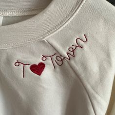 Bella Canvas Embroidered Sweatshirt! Show Your Alabama Spirit With This Cute Vintage White Embroidered Sweatshirt "T Heart Town"! -Supersoft Pullover Sweatshirt With Ribbed Cuffs -Relaxed Fit -Falls Right At The Hip -52% Airlume Cotton, 48% Polyester Fleece -Small Fits 30-32" Chest, Medium Fits 32-34" Chest, Large Fits 36-38" Chest Cotton Crew Top With Machine Embroidery, Embroidered Cotton Crew Top, Hand Embroidered College Sweatshirt, Crew Cotton Top With Machine Embroidery, Cotton Crew Neck Top With Machine Embroidery, Cute Crew Neck Tops With Custom Embroidery, Embroidered Relaxed Fit Sweatshirt For College, Red Long Sleeve Top With Letter Embroidery, College Fleece Tops With Custom Embroidery