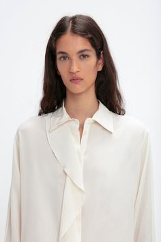 A single asymmetric drape detail cascades down the front of this silk blouse for a fluid silhouette that is enhanced by voluminous sleeves finished with buttoned cuffs. A concealed button-front closure maintains the elegant aesthetic, while the milky shade of Ivory has a nostalgic, romantic appeal. Styled with the Reverse Front Trouser Victoria Beckham Asymmetric Ruffle Blouse In Ivory  - Size 8 UK Winter Jasmine, Voluminous Sleeves, Elegant Aesthetic, Smocked Top, By Malene Birger, Minimal Style, Woven Top, Thom Browne, Blouse Styles