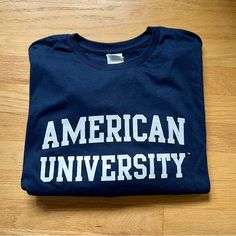 Nwot American University Tee 100% Pre-Shrunk Cotton Fan Apparel Cotton T-shirt For Campus, Navy Pre-shrunk Cotton T-shirt, Navy Cotton Top For College, Navy Cotton Tops For College, Collegiate Navy Cotton Top, Navy Cotton Fan Apparel Tops, Casual Navy Shirt With Letter Print, Cotton Long Sleeve T-shirt For Campus, Campus Logo Print Crew Neck T-shirt