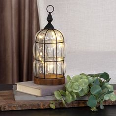 a lamp that is sitting on top of a table next to a book and plant