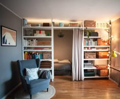 a living room filled with furniture and bookshelves next to a doorway that leads to a bedroom