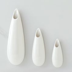 three white vases sitting next to each other