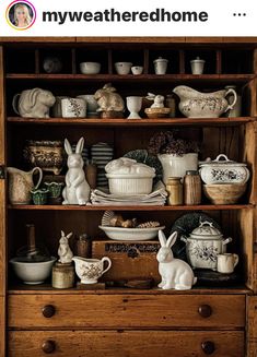 a wooden cabinet filled with dishes and vases