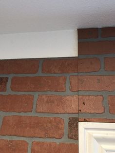 the corner of a brick wall with a white door