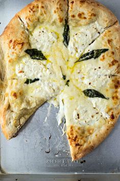 a pizza with cheese and spinach leaves on it