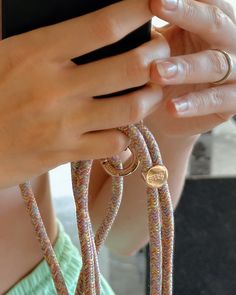 a woman is holding her cell phone up to her ear with two rings on it