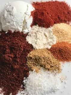 various spices are mixed together on a white plate with a scoop of ice cream in the middle