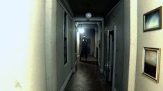 a person walking down a long hallway in an empty building with pictures on the wall