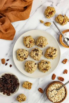 cookies and granola on a plate next to bowls of oatmeal raisins