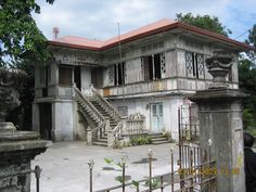 an old, run down house with stairs leading up to it