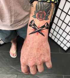 a person with a tattoo on their arm holding two scissors and a rose behind them