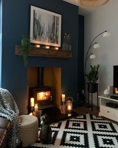 the living room is decorated with candles and pictures on the wall above the fire place