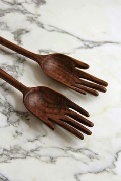 two wooden forks sitting on top of a marble counter