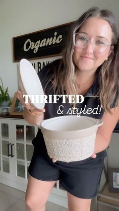 a woman is holding a white bowl with lace on it and the words thrifted & styled above her