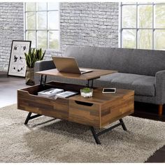 a living room with a couch, coffee table and laptop