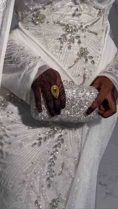 a close up of a person wearing a wedding dress and holding something in their hand