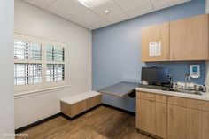 an empty room with wooden cabinets and white counter tops in the center of the room