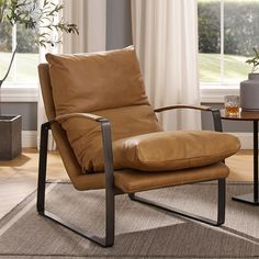 a brown chair sitting on top of a rug next to a window