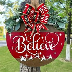 a wooden sign that says believe hanging on a tree