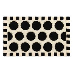 a black and white rug with polka dots on the front, in an oval pattern