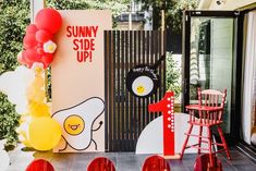 an outdoor party with balloons and decorations on the side of the building that says sunny side up