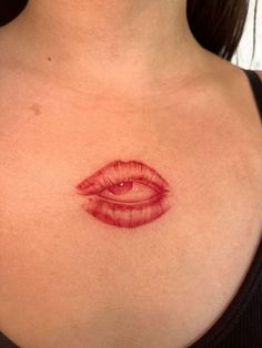 a woman's chest with an eye tattoo on the top part of her breast