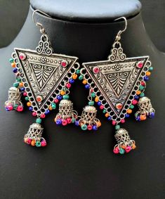 Stand out wearing these eye catching, fun and flirty triple jhumka Indian earrings, in oxidized silver with colorful dangly beads. Hand crafted. Excellent quality and craftsmanship. Nicely detailed triangular center with sparkly small glass inserts at each corner. Comfortable to wear. Height: 3 1/2 in Width: 2 1/2 in Weight: 17 gm Shop more earrings here: https://www.etsy.com/shop/boutiquebymaryam?section_id=22797814 Shop BoutiqueByMaryam: https://www.etsy.com/shop/boutiquebymaryam All my jewelr Multicolor Metal Earrings For Festivals, Bohemian Jhumkas For Party, Multicolor Chandbali Earrings For Festival, Bohemian Multicolor Metal Danglers, Bohemian Danglers For Festivals, Bohemian Metal Danglers For Party, Handmade Multicolor Jhumkas For Navratri, Multicolor Metal Chandbali Danglers, Multicolor Chandbali Danglers With Beads