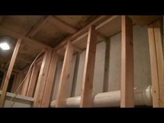 an unfinished room with pipes in the wall and some wood framing around the pipe area