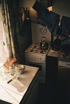 a kitchen with a stove, sink and window