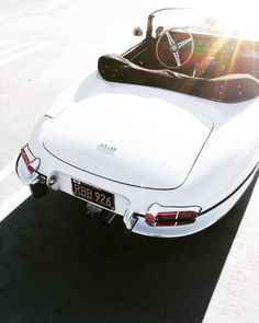 an old white car is parked on the street