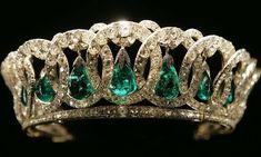 an emerald and diamond tiara is shown in this image, with diamonds surrounding the tiara