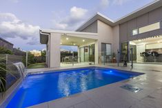 a house with a swimming pool in front of it and a glass door leading to the outside