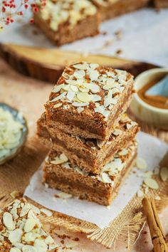 several pieces of cake sitting on top of each other next to some cinnamon sticks and spoons