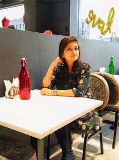 a woman sitting at a table in front of a sign that says love on it