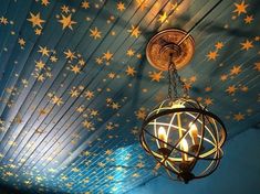 a chandelier hanging from the ceiling with stars painted on it's walls