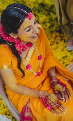 a woman sitting in a chair with flowers around her face