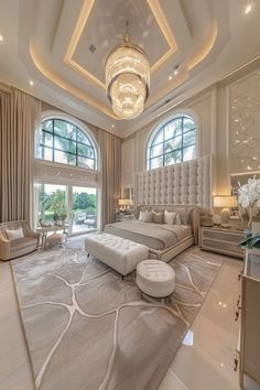 the large bedroom has an elegant chandelier above the bed, and is decorated in white